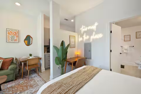 Studio with neon sign, desk, and dining nook