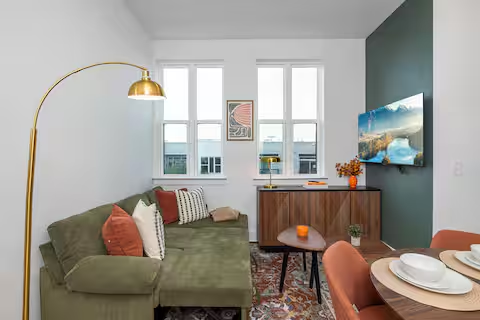 Living area with green sectional and gold arc lamp