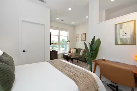 Bright studio with bed, desk, and seating area